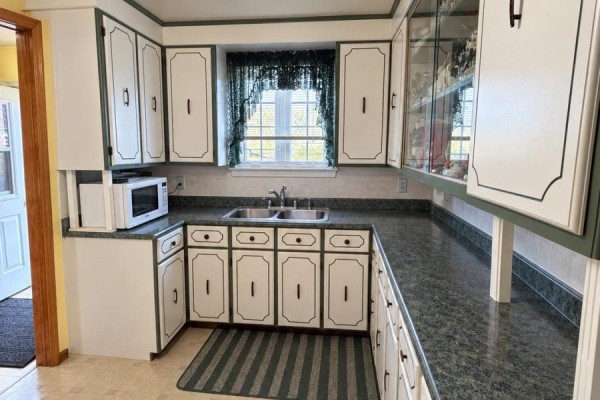 Kitchen with white cabinets, green trim, and dark green countertops. - 12 Welsh's Lane, Pouch Cove