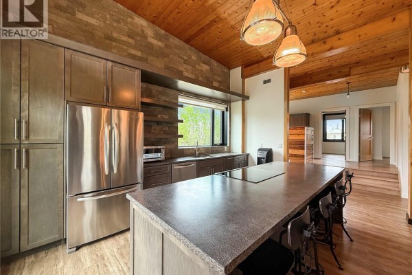 Entrance to house with glass door, large window, and wooden deck. - 12/14 Bruin Boulevard, Candle Lake