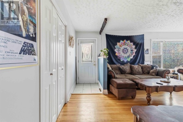 Interior hallway with white doors, a glass-paneled front door, and a living room beyond. - 12/14 Laurie Street, Waverley