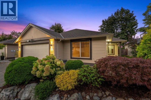 Open-concept living area with hardwood floors, large windows, and a sectional sofa. - 120 2205 Robert Lang Dr, Courtenay
