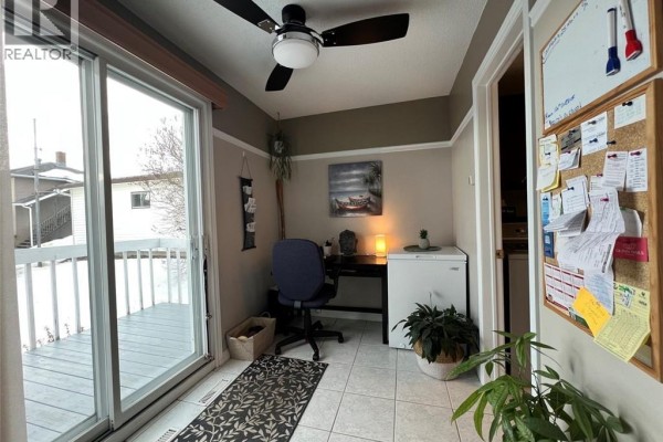 Another angle of the kitchen and dining area, showcasing natural light and tile flooring. - 120 34th Avenue, Edmundston