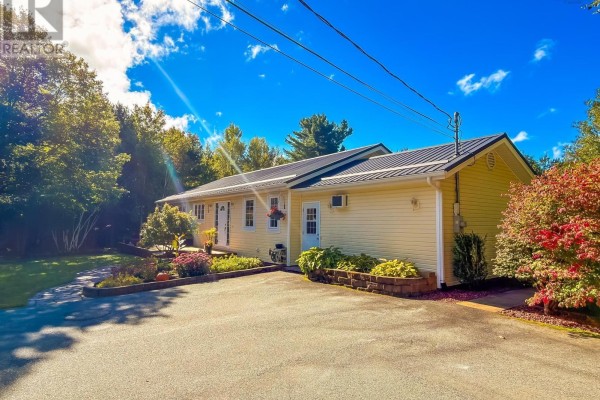 Side view of yellow single-story house with double driveway and landscaping. - 120 Dawson Heights, Pine Grove