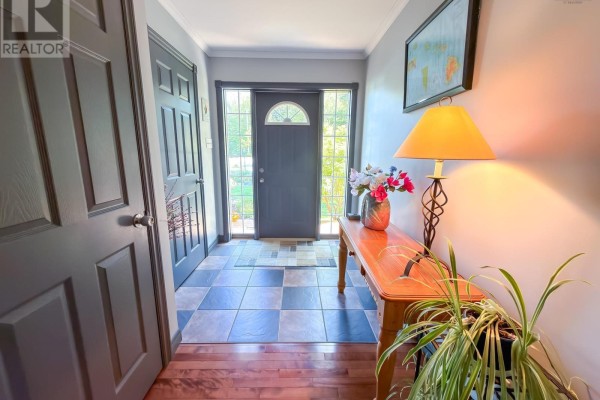 Foyer with dark gray door, checkered tile floor, and wooden console table. - 120 Dawson Heights, Pine Grove