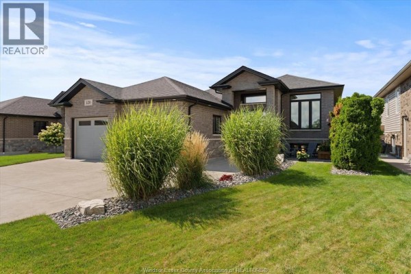 Front view of a modern brick house with manicured landscaping and a two-car garage. - 120 Golfview Drive, Kingsville