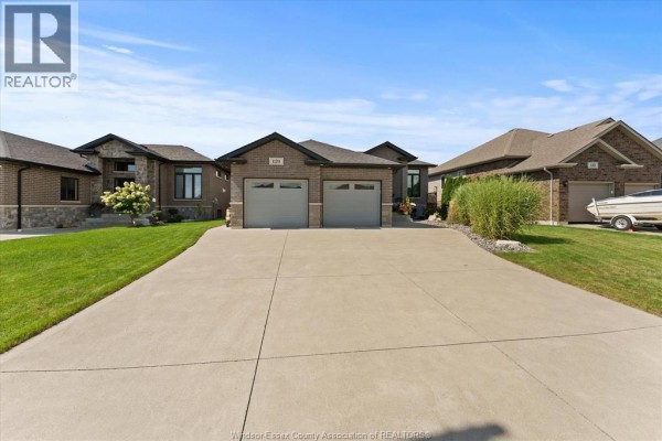 View of the house exterior from the driveway, showing the brick facade and landscaping. - 120 Golfview Drive, Kingsville