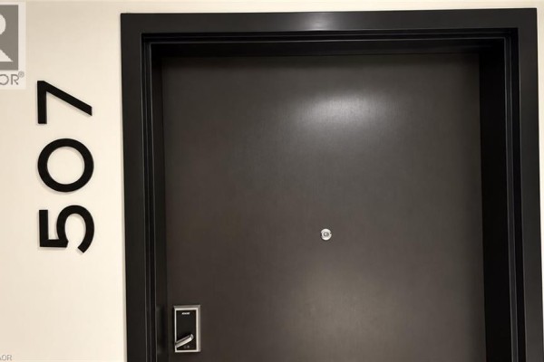 Close-up of the dark grey entrance door for unit 507 with the number displayed. - 120 Huron Street Unit# 507, Guelph