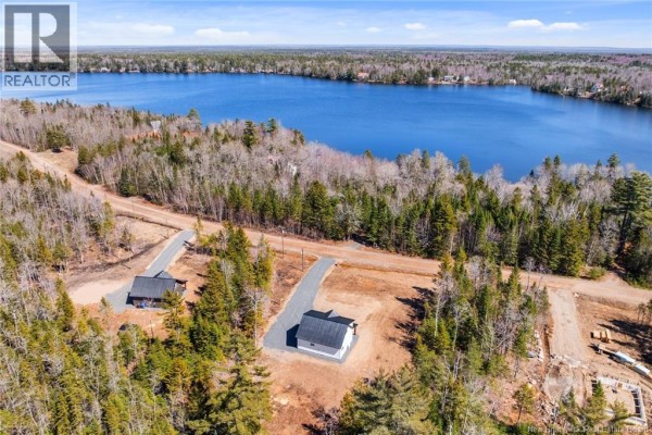 Aerial view of the area with a lake in the distance and nearby structures. - 120 John Chessie Dr, Yoho