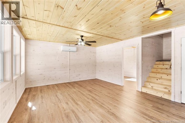 Interior view of a room with wooden ceiling, laminate flooring, and ceiling fan. - 120 John Chessie Dr, Yoho