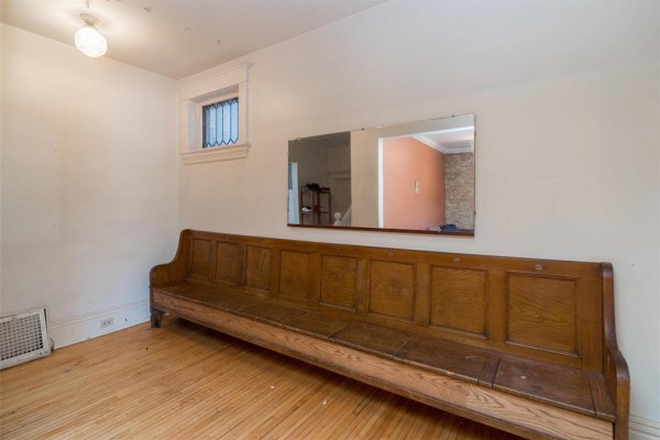 Living room with exposed brick wall, blue sofas, and track lighting - 120 Norquay Street, Winnipeg