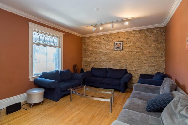Another angle of the living room showcasing a window and seating arrangement - 120 Norquay Street, Winnipeg