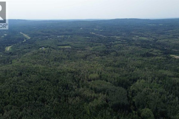 Aerial view of a vast expanse of forest with a road and water bodies visible. - 120 Range Road, Rural Woodlands County
