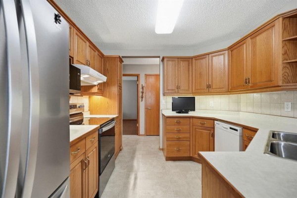 Kitchen with light wood cabinets, stainless steel appliances, and white countertops. - 120 Wyndstone Circle, East St Paul