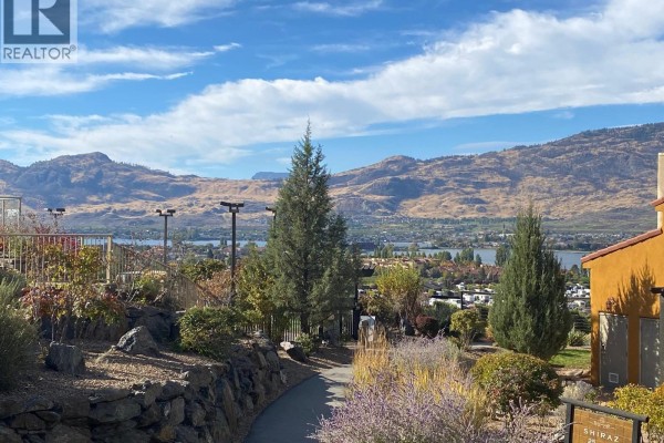 View of mountains and lake from landscaped grounds with trees and pathway. - 1200 Rancher Creek Road Unit# 115c, Osoyoos