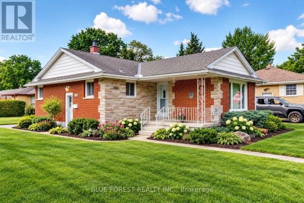 Exterior view of a single-family home with manicured lawn and flower beds. - 1201 Patann Drive N, London East