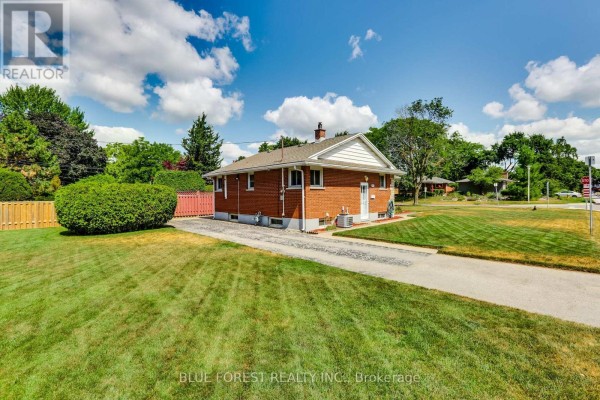 Back view of the house showing brick exterior, driveway, and lawn. - 1201 Patann Drive N, London East