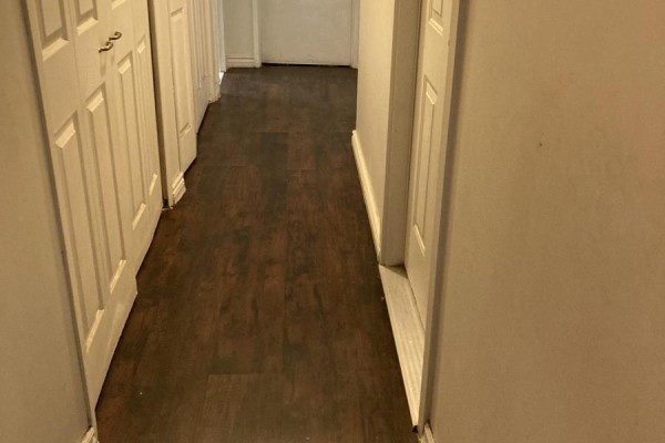 Hallway with dark wood flooring and white doors on both sides. - 1202 - 100 Lotherton Pathway, Toronto