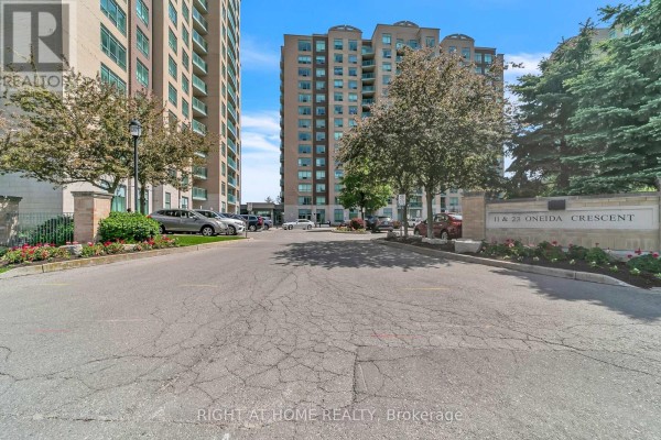 Entrance to the apartment building with glass doors and stone paving. - 1202 - 11 Oneida Crescent, Richmond Hill