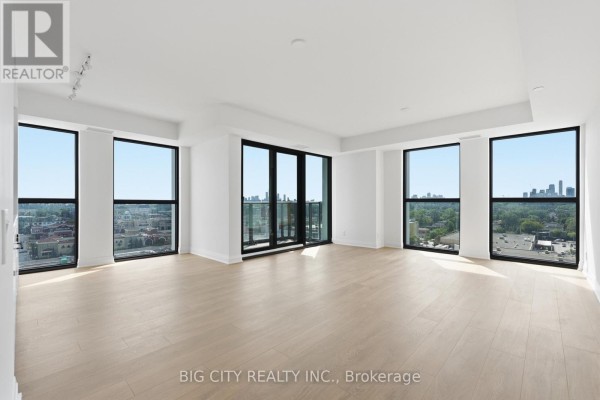 Spacious living room with floor-to-ceiling windows, sliding glass doors, and city views. - 1202 - 25 Frederick Way, Toronto