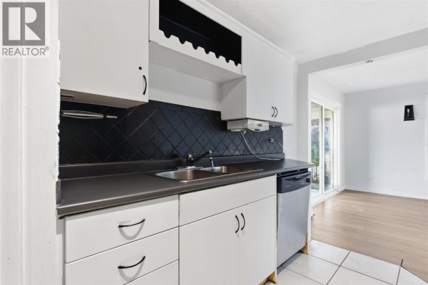 Kitchen with white cabinets, gray countertop, double sink, and dishwasher. - 1202 Crestwood Drive, Kamloops