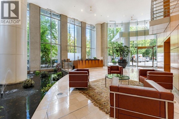 A bright, modern lobby with marble floors, leather chairs, a water feature, and large windows. - 1203 1288 Alberni Street, Vancouver