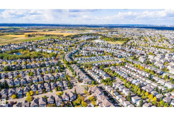Aerial view of a residential area with curved streets, many houses, and green spaces. - 12035 18 Av Sw, Edmonton