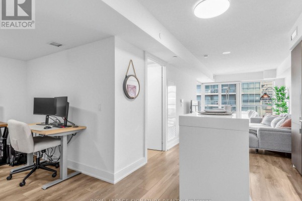 Apartment interior showing a home office area with a desk and dual monitors. - 1204 - 89 Mcgill Street, Toronto