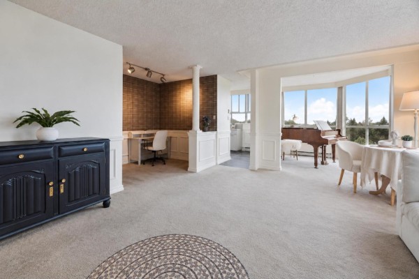 Living room area with a dark blue sideboard, desk, piano, and a large white sectional sofa. - 1204 11920 80 Avenue, Delta