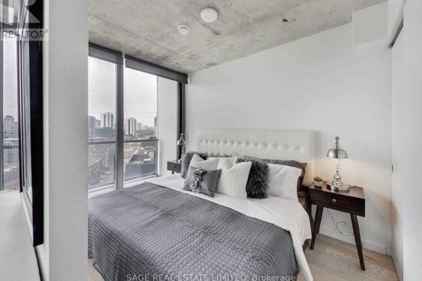 Bedroom with king-size bed, white tufted headboard, and dark wood nightstands. - 1205 - 170 Bayview Avenue, Toronto
