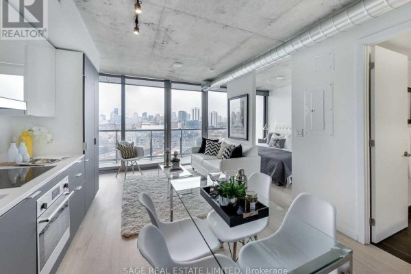 Open-concept living, dining, and kitchen area with city views from large windows. - 1205 - 170 Bayview Avenue, Toronto