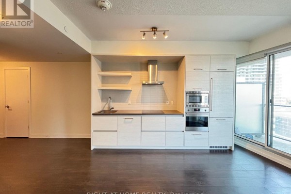 Empty room with beige walls and a white metal shelf bracket mounted high on the wall. - 1205 - 2221 Yonge Street, Toronto