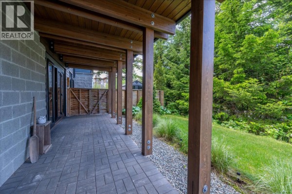 Covered patio with exposed wood beams and brick block walls. - 1205 Mount Fee Road, Whistler