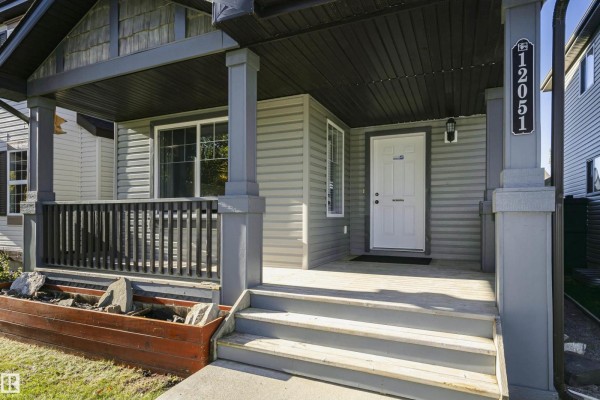 Close-up of the front porch with steps, railings, white door, and address number. - 12051 18 Av Sw Sw, Edmonton