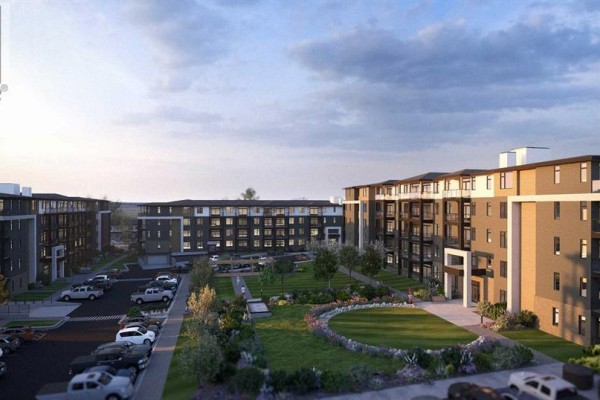 Aerial view of a multi-building apartment complex with a central courtyard, manicured lawn, and ample parking. - 1206, 14910 1 Street Nw, Calgary