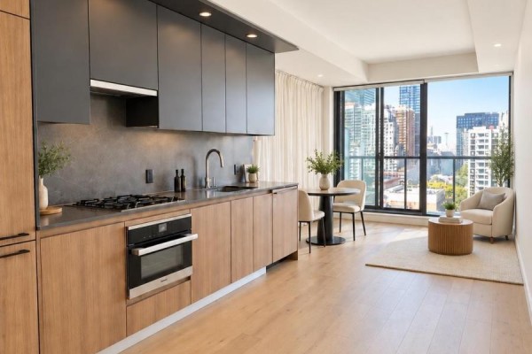 Kitchen with wood and dark grey cabinets, stainless steel appliances, and dining area. - 1206 - 81 Wellesley Street, Toronto