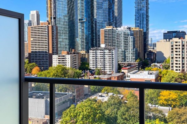 Balcony view overlooking Toronto skyline with trees and surrounding buildings. - 1206 - 81 Wellesley Street, Toronto