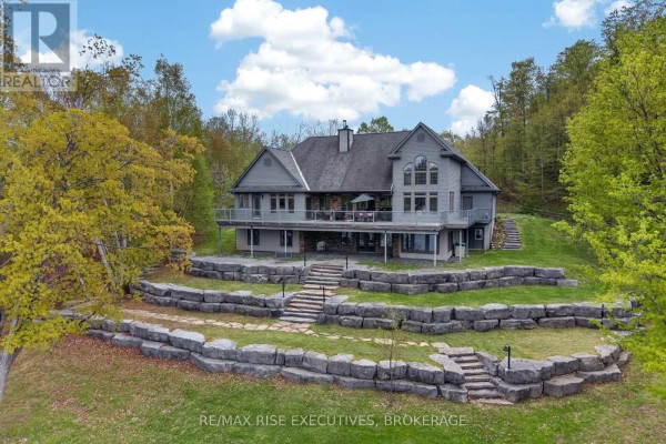 Modern kitchen with light wood cabinets, granite countertops, stainless steel appliances, and a breakfast bar. - 1206b Burnt Hills Road, Frontenac
