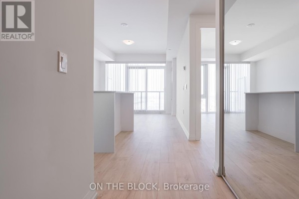Open concept living area with light wood floors and large windows. - 1207 - 27 Korda Gate, Vaughan