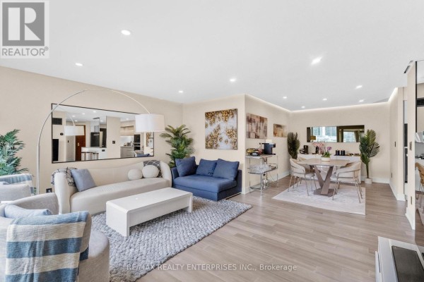 Open concept living and dining area with a round dining table and modern furniture. - 1208 - 1 Palace Pier Court, Toronto