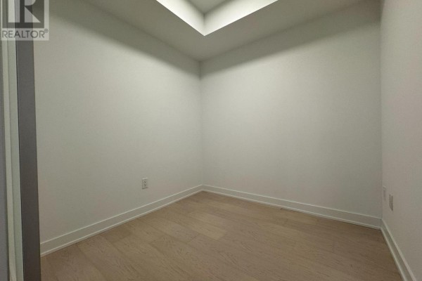 Empty room with light wood flooring and white walls, likely a bedroom or office. - 1208 - 252 Church Street, Toronto