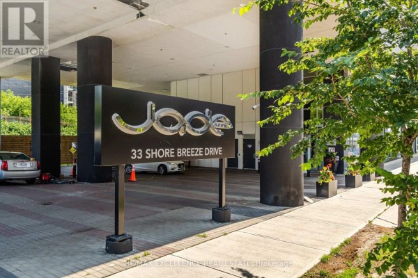 Building entrance sign reading "Joie 33 Shore Breeze Drive" with covered walkway. - 1208 - 33 Shore Breeze Drive, Toronto