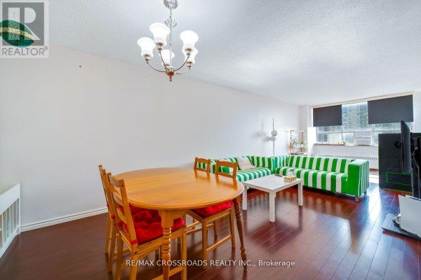 Living and dining area with striped sofa and dining table - 1208 - 340 Dixon Road Toronto