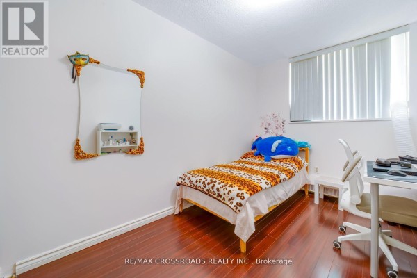 Bedroom with twin bed, desk, chair, and decorative mirror - 1208 - 340 Dixon Road Toronto