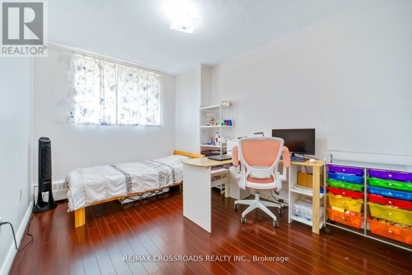 Bedroom with twin bed, desk, computer, and colorful storage cart - 1208 - 340 Dixon Road Toronto