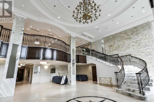 Grand building lobby with a sweeping marble staircase, dark wood railings, and ornate chandelier. - 1208 - 38 Cedarland Drive, Markham