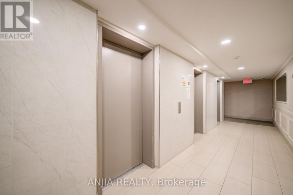 Hallway with elevator access, light-colored walls, and tiled flooring. - 1208 - 4727 Sheppard Avenue E, Toronto