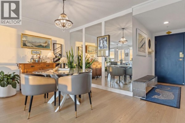 Dining area with upholstered chairs, mirrored wall, and a dark blue front door. - 1208 10 Laguna Court, New Westminster