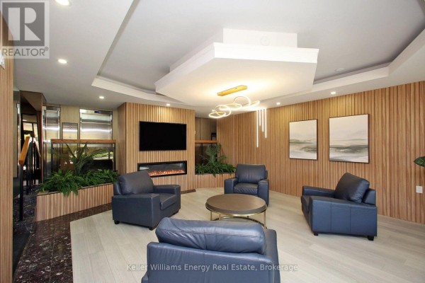 Apartment building lobby with dark blue armchairs, a fireplace, and modern light fixtures. - 1209 - 1210 Radom Street, Pickering