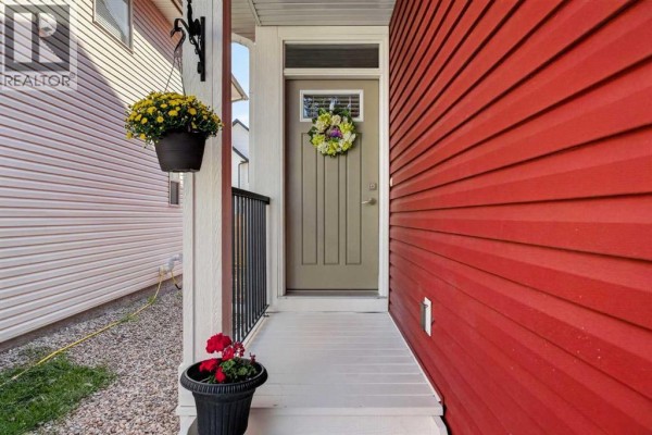 Entrance hallway with a staircase, console table, rug, and doorway to living area. - 1209 Copperfield Boulevard Se, Calgary