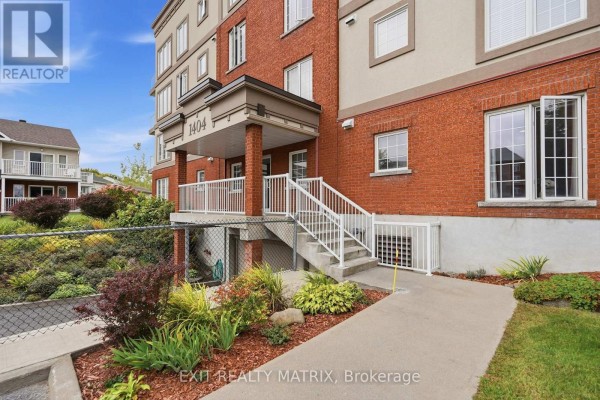 Close-up of the apartment building's main entrance with brick facade and outdoor stairs. - 121 - 1404 Clement Street, Hawkesbury