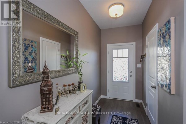 Interior entryway with light brown walls, gray flooring, and large mirror. - 121 - 1924 Cedarhollow Boulevard, London North